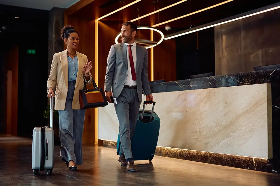 Deux clients d'affaires arrivent avec leurs valises dans le hall d'un hôtel